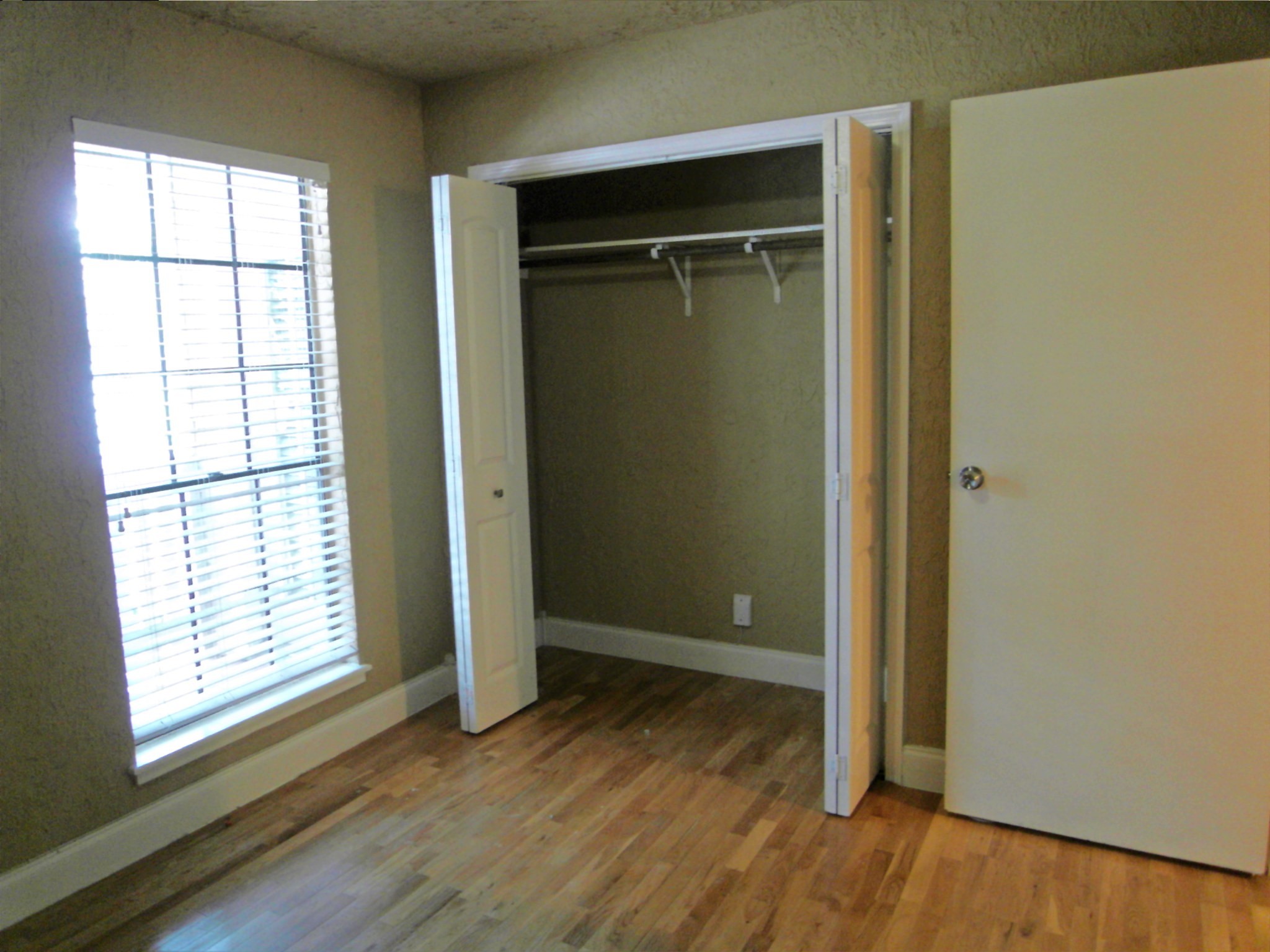 14911 Wunderlich Drive, Unit 1108 Houston, TX 77069 - Photo 17 of 26 an empty room with wooden floor closet and windows