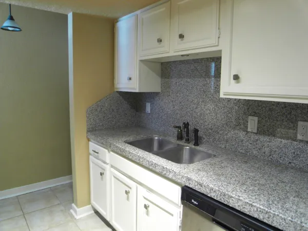 a kitchen with granite countertop a sink and stainless steel appliances