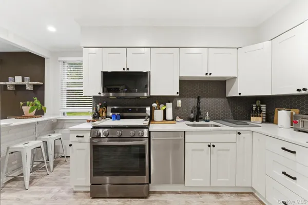a kitchen with stainless steel appliances a stove and a sink