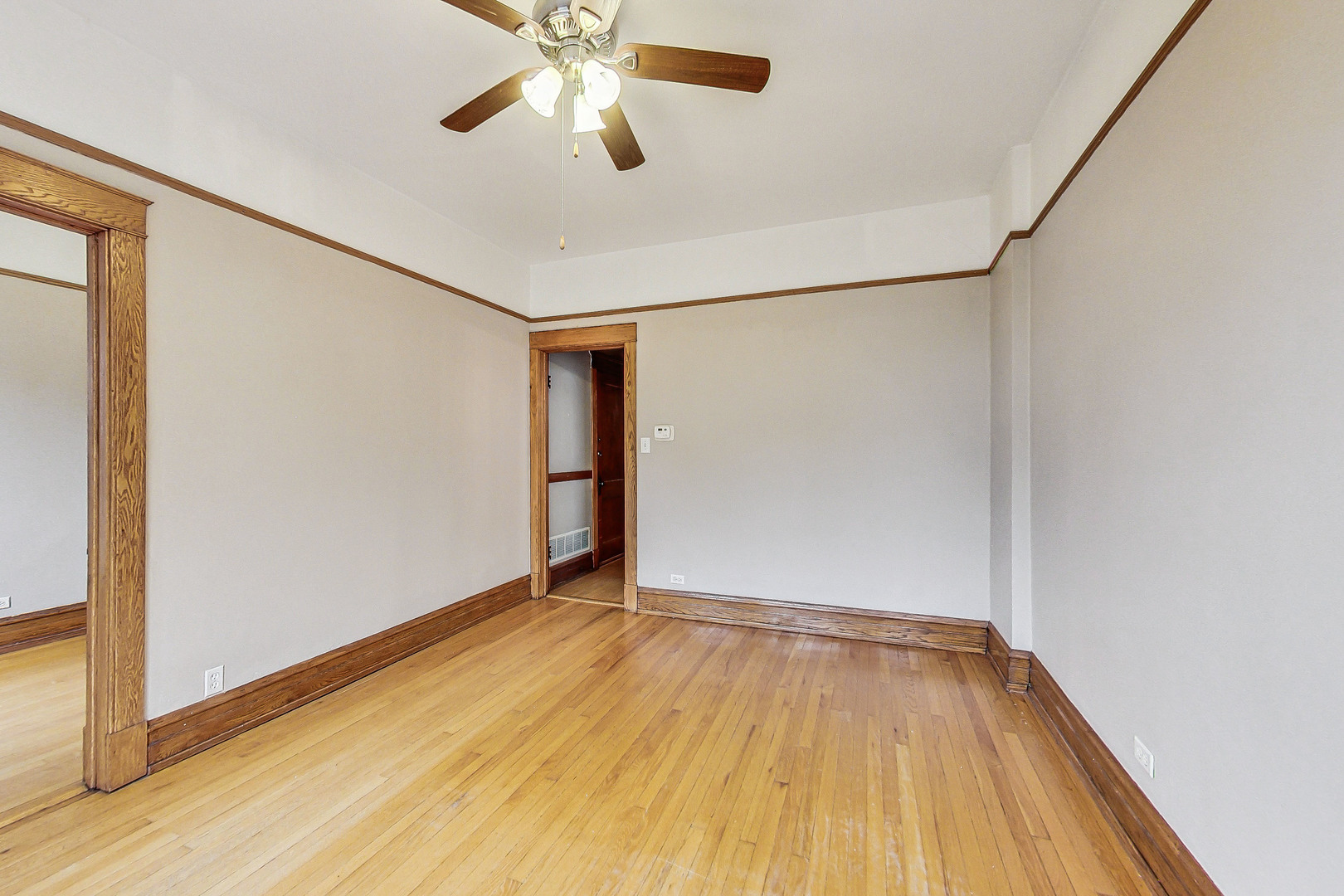 1312 West Nelson Street, Unit 3 Chicago, IL 60657 - Photo 3 of 15 an empty room with wooden floor closet and windows