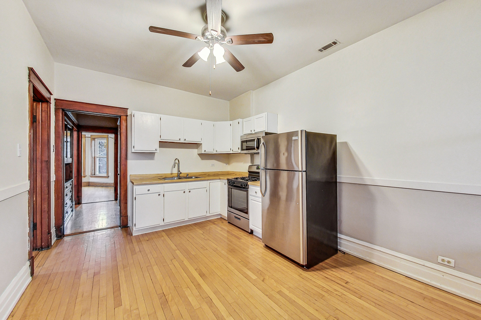 1312 West Nelson Street, Unit 3 Chicago, IL 60657 - Photo 5 of 15 a kitchen with a refrigerator and a stove top oven