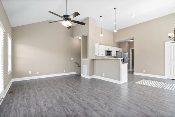 a view of a kitchen with a dishwasher a refrigerator and wooden floor