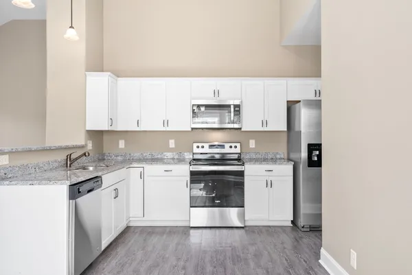 a kitchen with stainless steel appliances granite countertop a stove a sink and a refrigerator