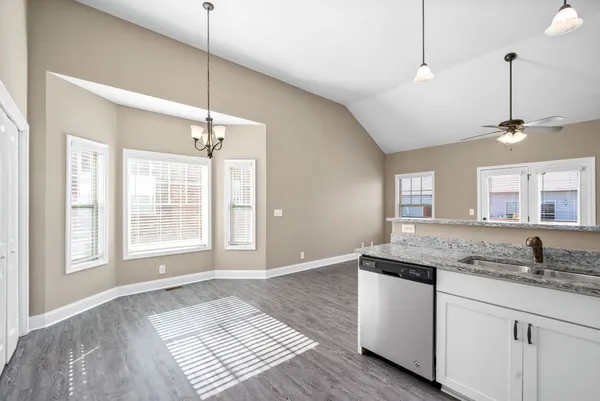 a kitchen with kitchen island granite countertop a stove a sink and a window