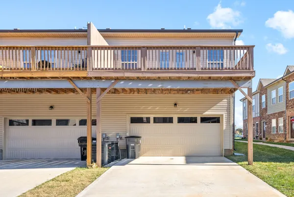 a front view of a building with a garden and a chair