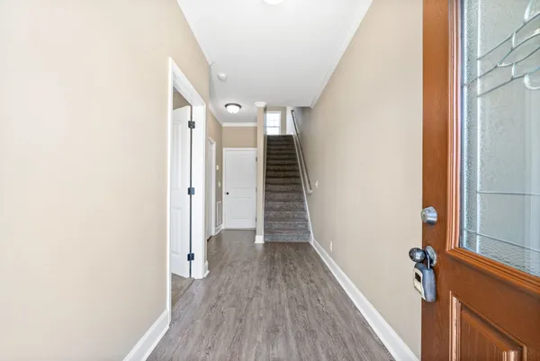 a view of a hallway with wooden floor and staircase