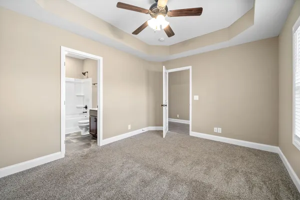 an empty room with closet and a ceiling fan