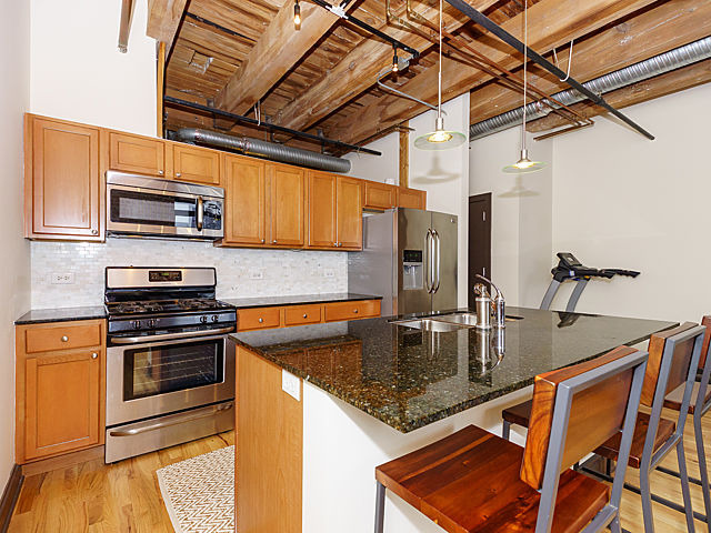106 North Aberdeen Street, Unit 4B Chicago, IL 60607 - Photo 2 of 17 a kitchen with stainless steel appliances granite countertop a sink a stove and cabinets