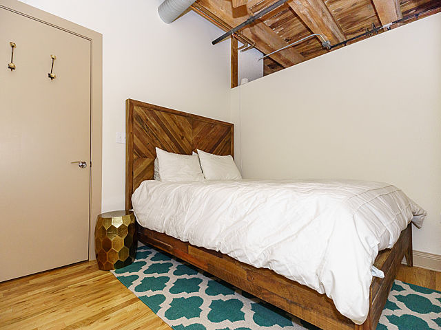 106 North Aberdeen Street, Unit 4B Chicago, IL 60607 - Photo 8 of 17 a bedroom with a bed and wooden floor