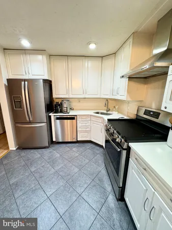a kitchen with stainless steel appliances a sink a stove a refrigerator and cabinets
