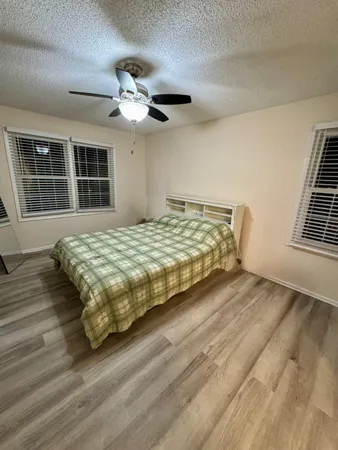 a bedroom with a large bed chandelier and a window