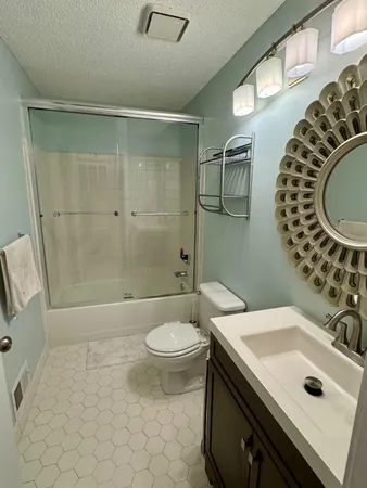 a bathroom with a sink a toilet and shower