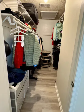 a view of walk in closet with clothes
