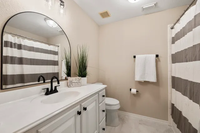 a bathroom with a sink a toilet and mirror