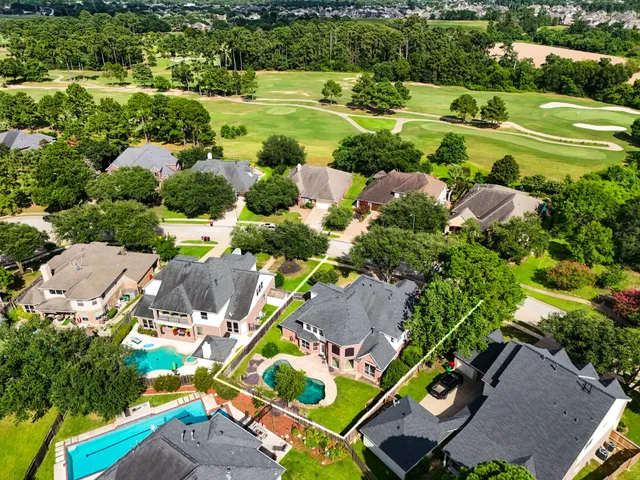 an aerial view of a residential houses with outdoor space and street view