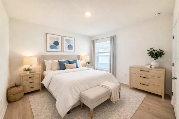 a bedroom with a bed and a potted plant