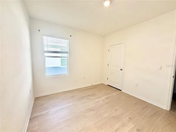 an empty room with windows and closet