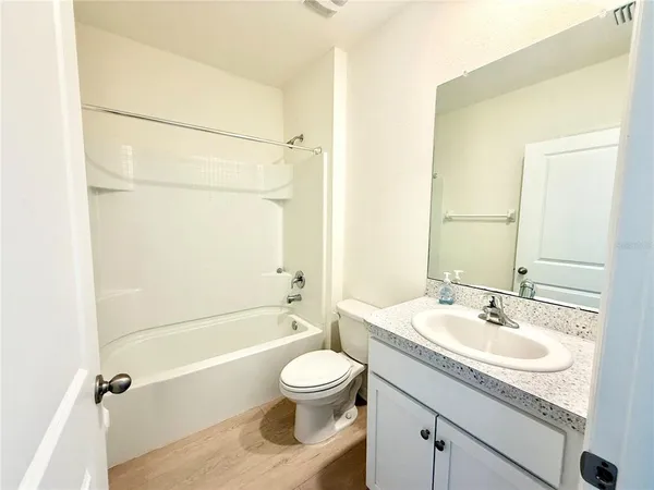 a bathroom with a granite countertop sink toilet a shower and a mirror