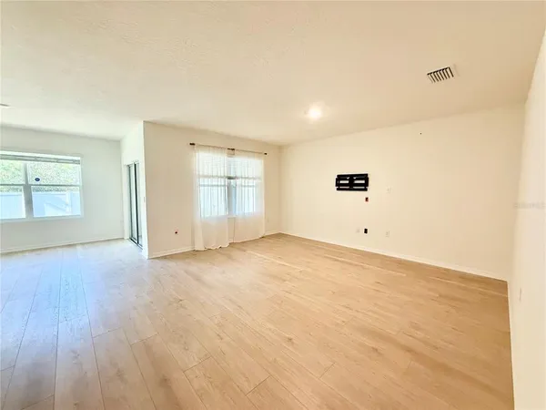 a view of empty room with wooden floor