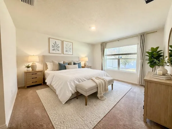 a bedroom with a large bed and a potted plant