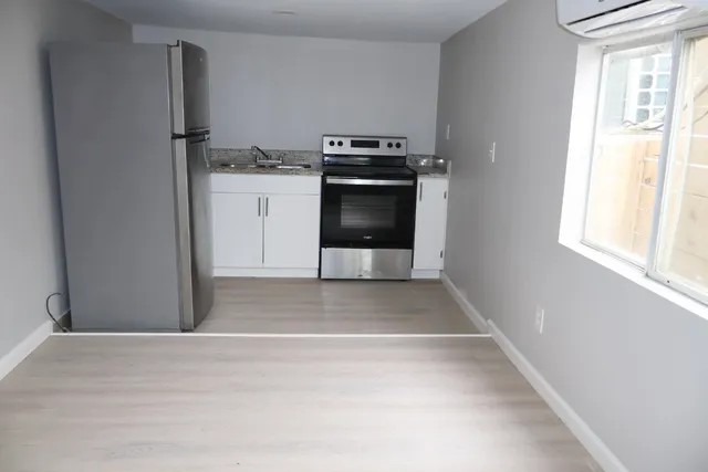 a view of a kitchen with a stove wooden floor and a window