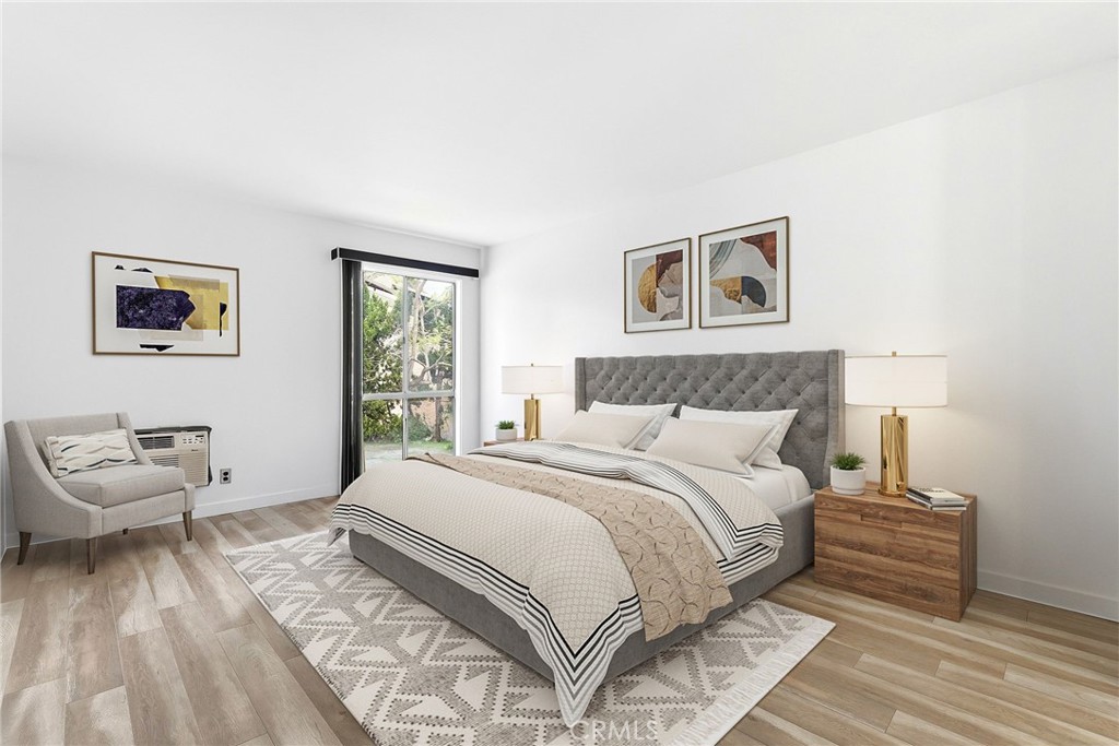 7890 East Spring Street, Unit 11E Long Beach, CA 90815 - Photo 31 of 40 a bedroom with a bed and wooden floor