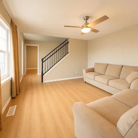 a living room with furniture and a ceiling fan