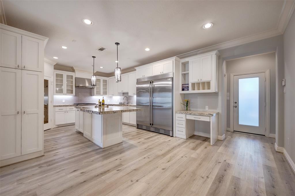 an open kitchen with white cabinets and stainless steel appliances