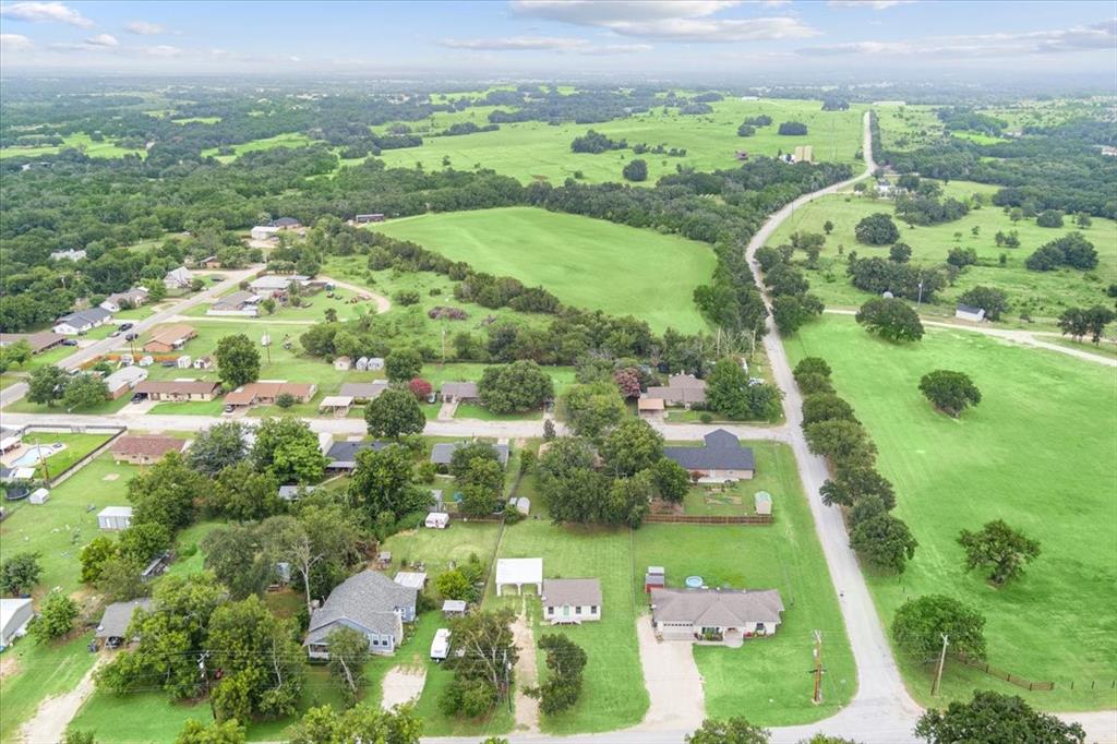 608 9th Street Hico, TX 76457 - Photo 23 of 23 Aerial perspective showcasing a residential area bordered by expansive green fields and scattered trees