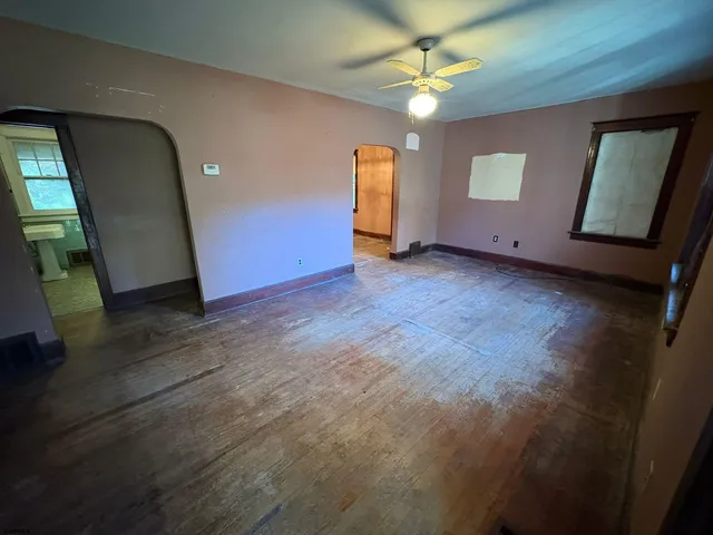 an empty room with window and wooden floor