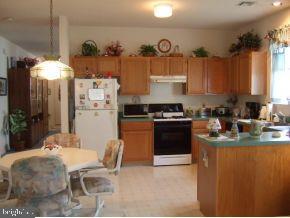 47 Quail Road Barnegat, NJ 08005 - Photo 5 of 12 a kitchen with stainless steel appliances granite countertop a refrigerator a stove a sink dishwasher and white cabinets with wooden floor