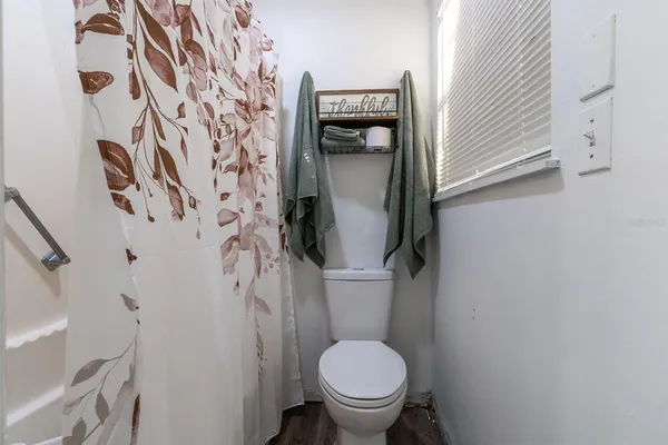 a white toilet sitting next to a shower curtain