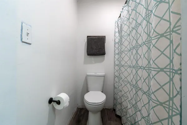 a bathroom with a toilet and a shower curtain