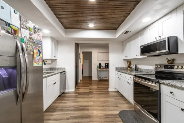 a kitchen with stainless steel appliances granite countertop a refrigerator a stove microwave and cabinets