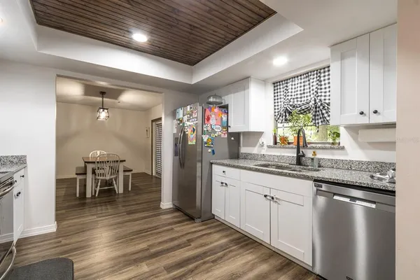 a kitchen with stainless steel appliances granite countertop a stove refrigerator and cabinets