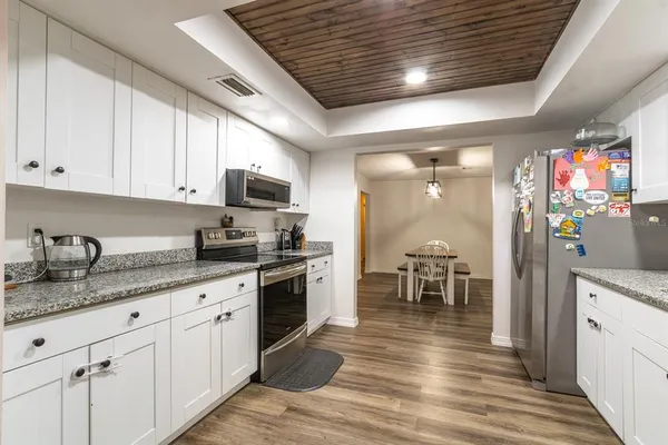 a kitchen with granite countertop a stove sink and cabinets