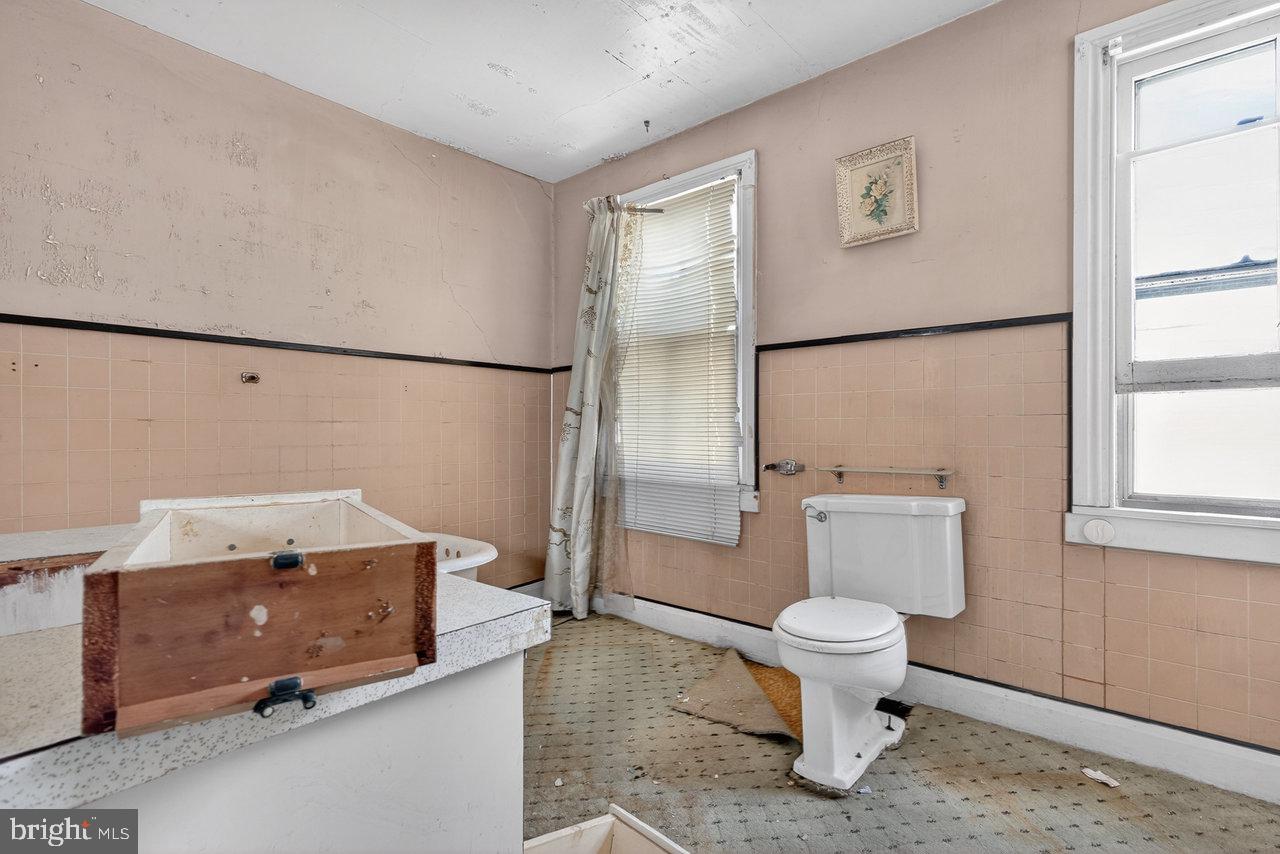 12 Church Street Salem, NJ 08079 - Photo 9 of 15 a white toilet sitting next to a bathroom sink