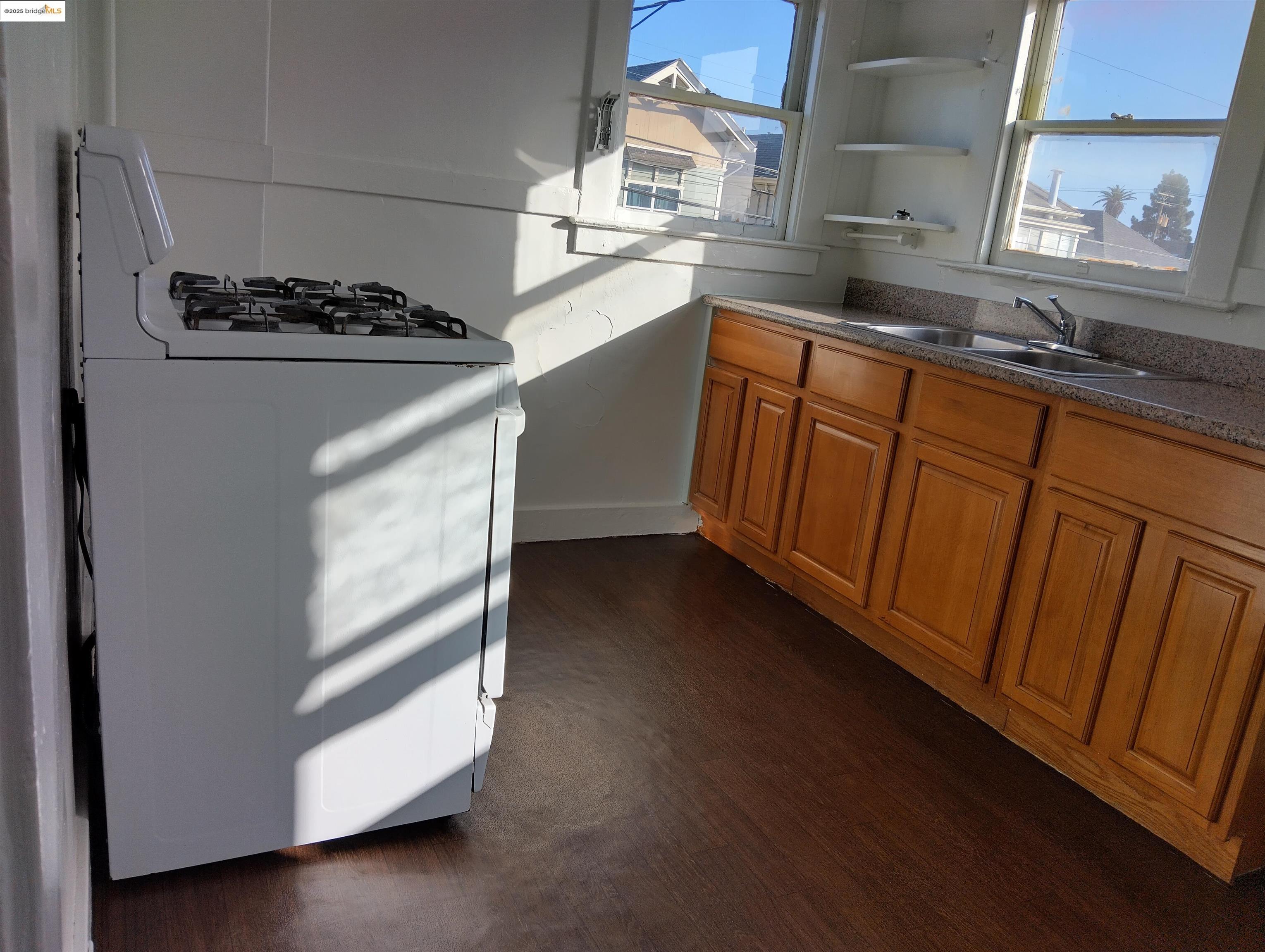 847 East 18th Street Oakland, CA 94606 - Photo 12 of 60 a kitchen with granite countertop white cabinets and white appliances