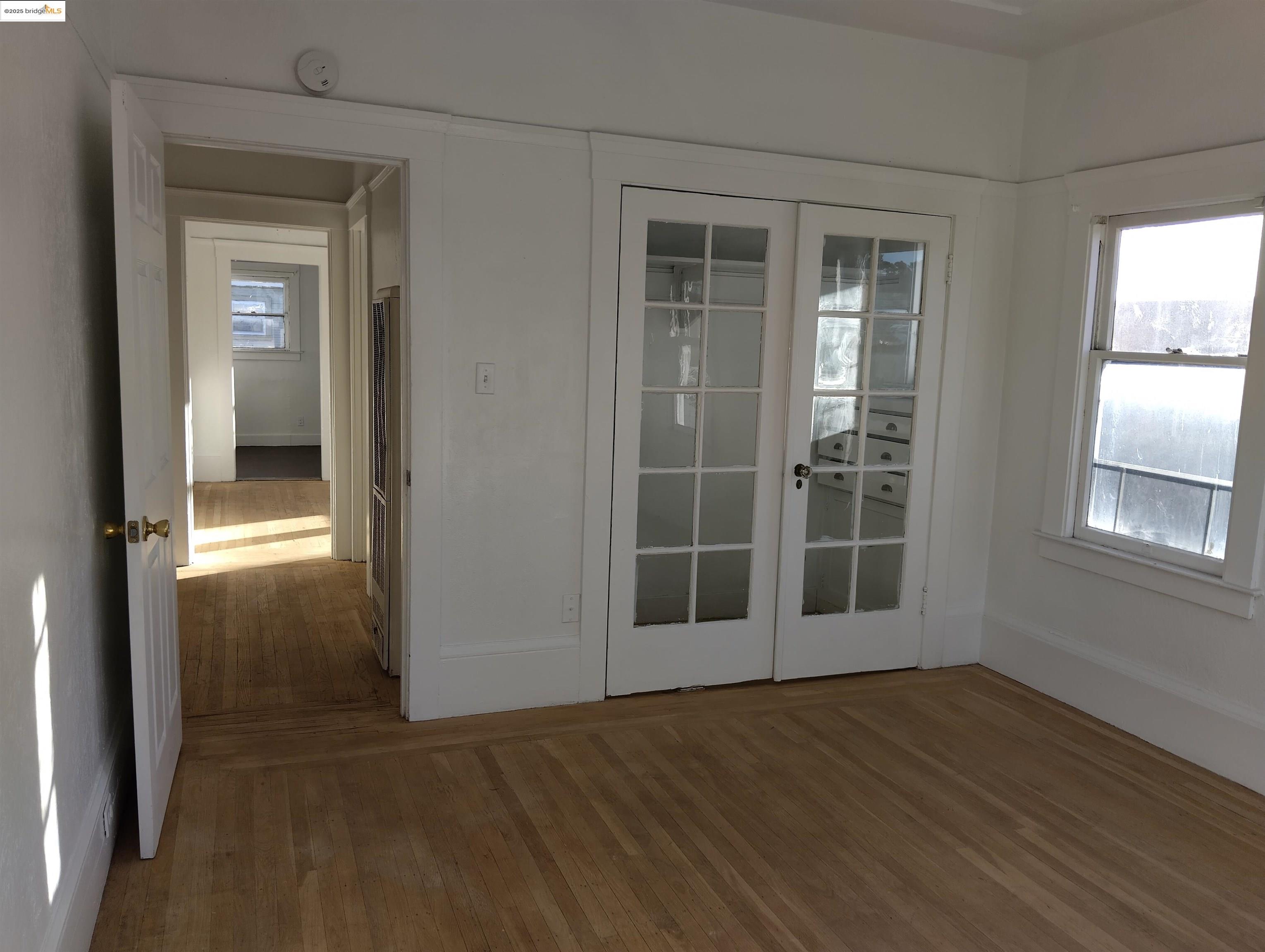 847 East 18th Street Oakland, CA 94606 - Photo 23 of 60 an empty room with wooden floor and windows
