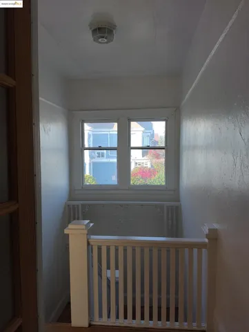 an empty room with wooden floor closet and windows
