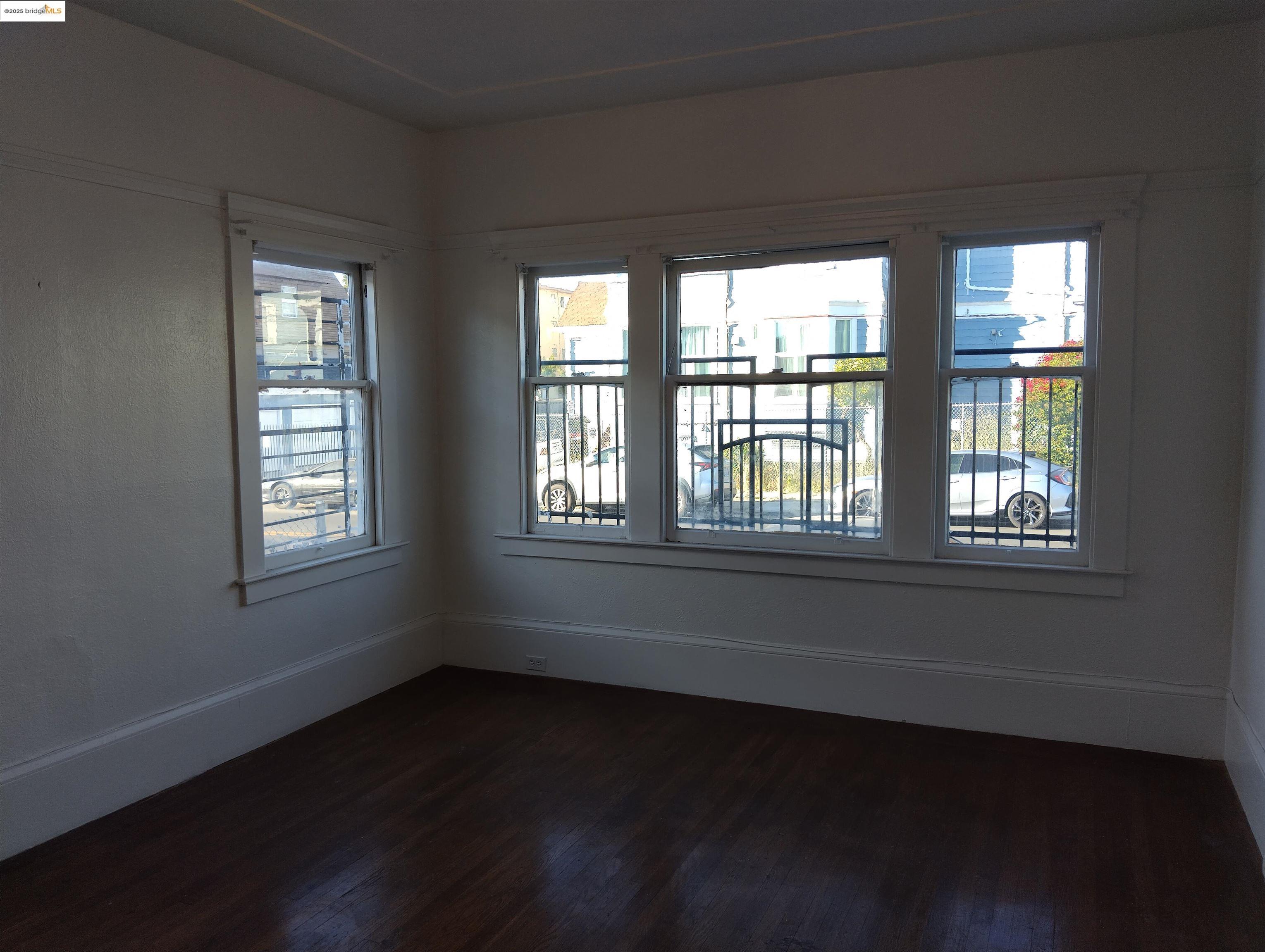 847 East 18th Street Oakland, CA 94606 - Photo 43 of 60 a view of an empty room with wooden floor and a window