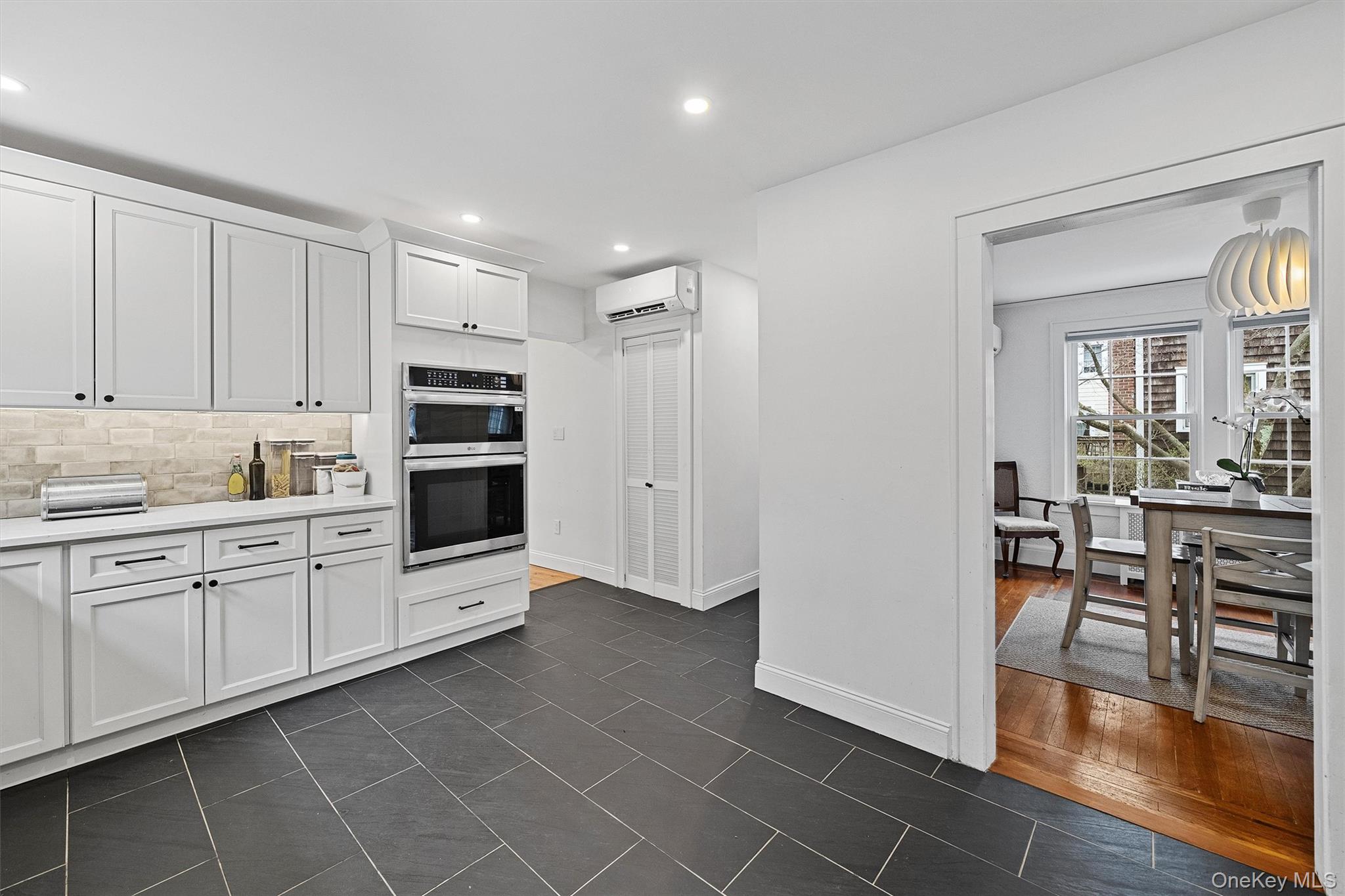 112 Ralph Avenue White Plains, NY 10606 - Photo 12 of 30 Kitchen featuring tasteful backsplash, white cabinets, light countertops, and stainless steel double oven