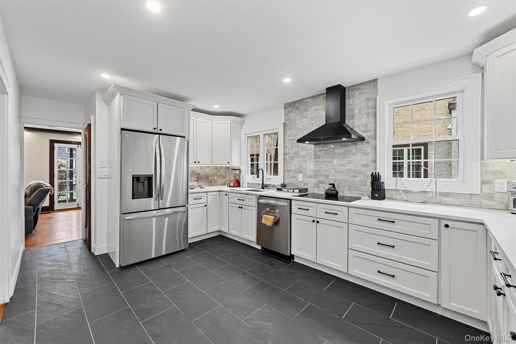 112 Ralph Avenue White Plains, NY 10606 - Photo 14 of 30 Kitchen featuring wall chimney range hood, tasteful backsplash, stainless steel appliances.