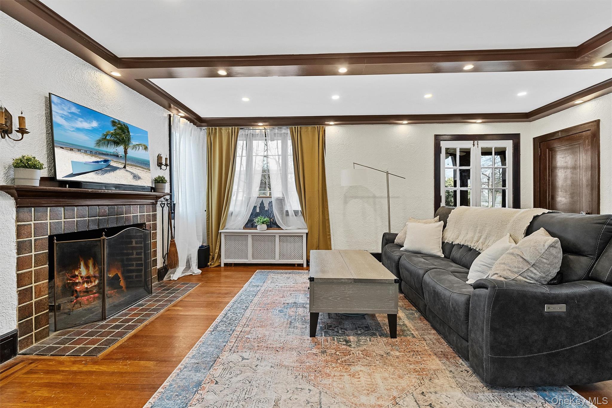112 Ralph Avenue White Plains, NY 10606 - Photo 5 of 30 Living area with ornamental molding, recessed lighting, wood finished floors, a brick fireplace, and a textured wall