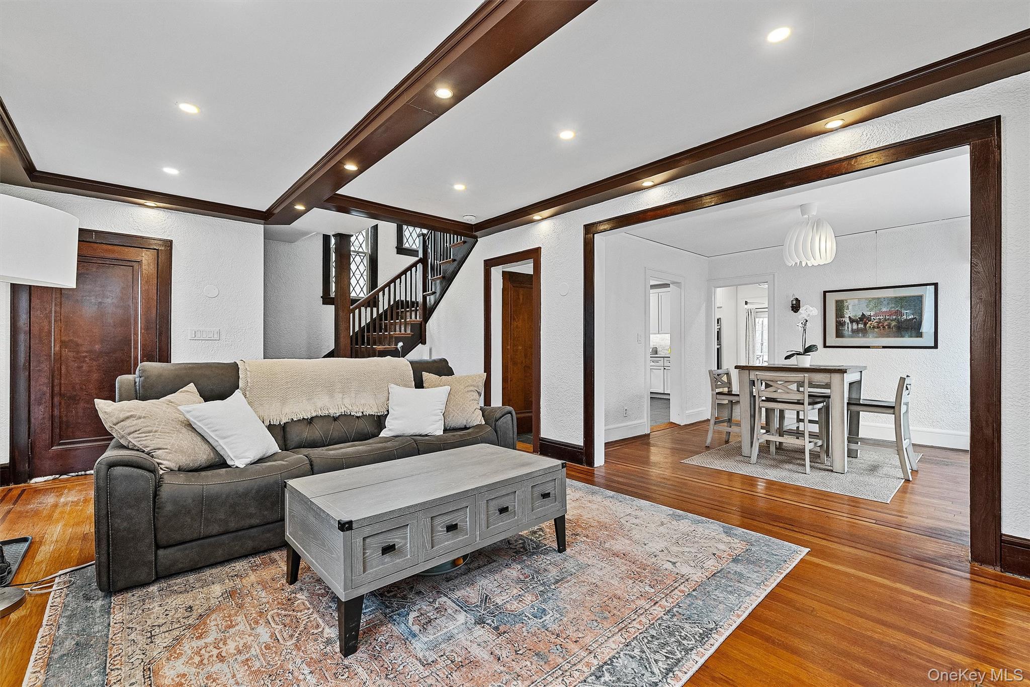 112 Ralph Avenue White Plains, NY 10606 - Photo 7 of 30 Living room featuring a textured wall, stairway, baseboards, and wood finished floors