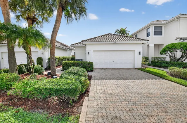 a front view of a house with a yard and potted plants