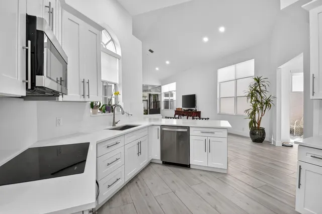 a kitchen with white cabinets and stainless steel appliances