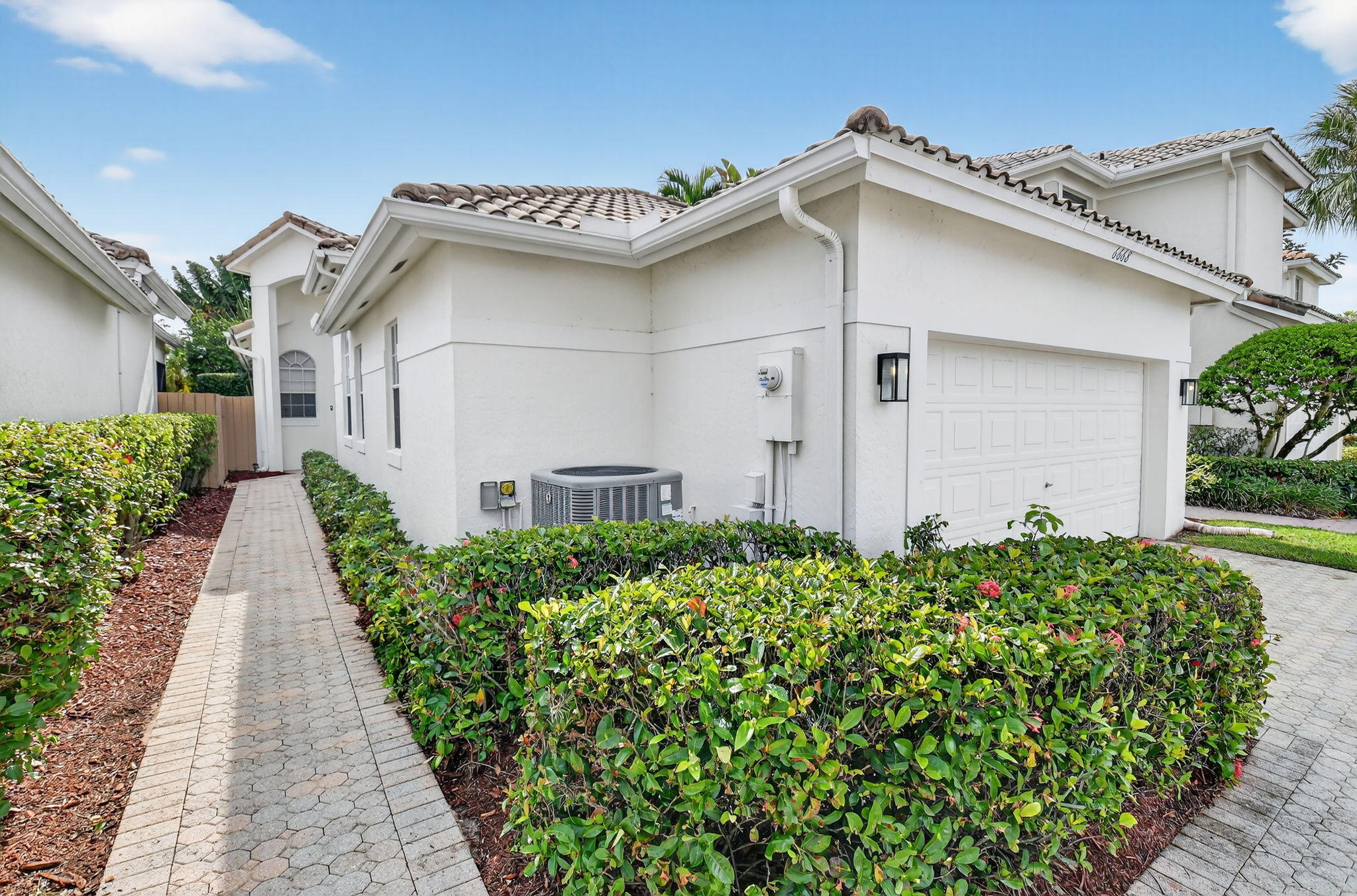 6668 Northwest 25th Terrace Boca Raton, FL 33496 - Photo 3 of 53 a white house with a small yard and plants