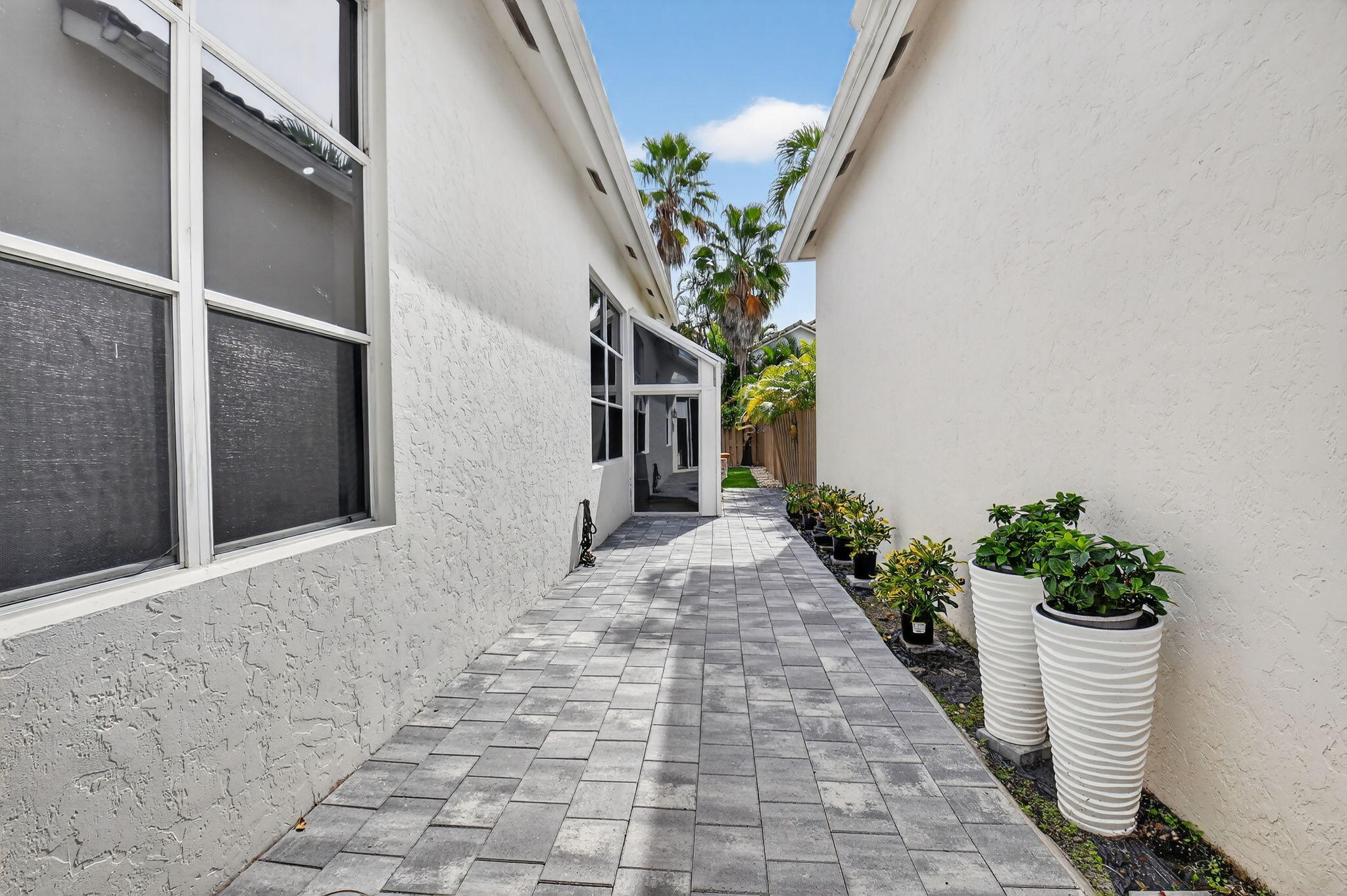 6668 Northwest 25th Terrace Boca Raton, FL 33496 - Photo 37 of 53 a potted plant sitting in front of a house