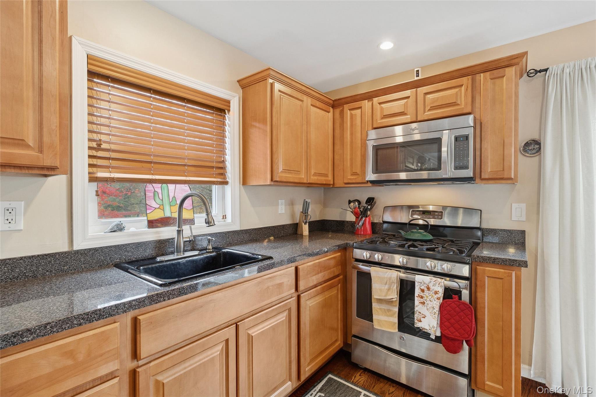 31 Amityville Road Sound Beach, NY 11789 - Photo 21 of 33 a kitchen with stainless steel appliances granite countertop a stove a sink and a microwave